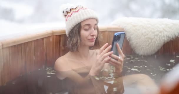 Karlı dağlarda sıcak küvette dinlenen bir kadın. — Stok video