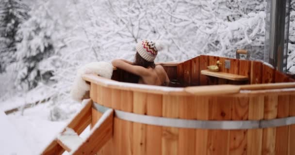 Woman relaxing in hot vat at mountains in winter — стоковое видео