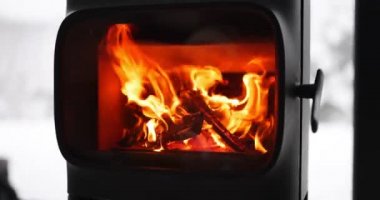 Woman with a hot drink by the fireplace indoors