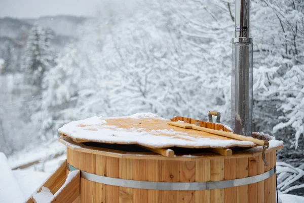Drewniany gorący zbiornik na zaśnieżonym tarasie w górach — Zdjęcie stockowe