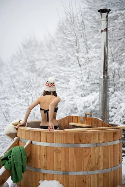Kobieta kąpiąca się w gorącej kadzi na zewnątrz w śnieżnych górach — Zdjęcie stockowe