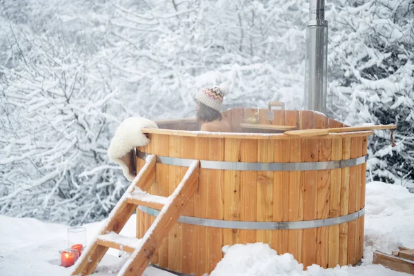 Mujer relajante en baño caliente en las montañas nevadas — Foto de Stock