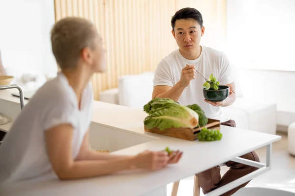 家庭で新鮮な野菜からサラダを食べるカップル — ストック写真