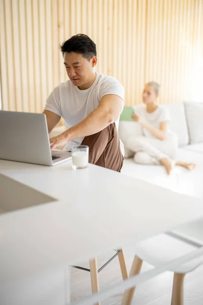 Multiracial couple using digital devices at home — Stock Photo, Image