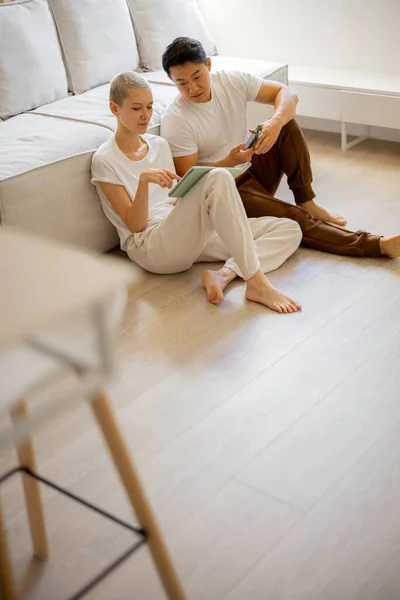 Pár sedět a mluvit na podlaze s digitálním tabletem — Stock fotografie