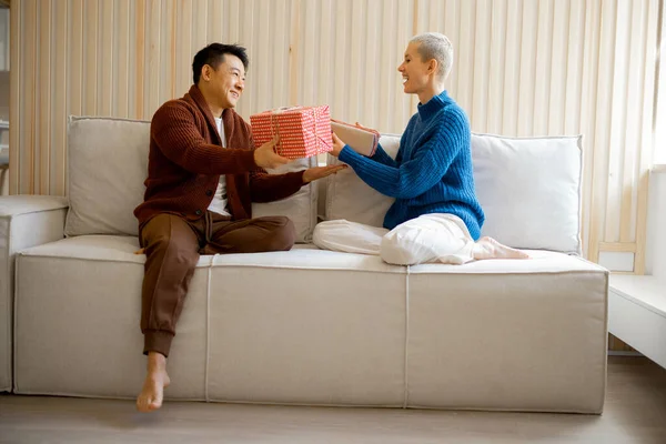 Aziatisch man en jonge vrouw geven geschenken elkaar — Stockfoto
