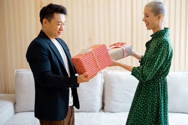 Asian man and young woman giving gifts each other — Stock Photo, Image
