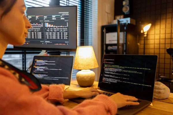 Programadora femenina escribiendo código de programación en un acogedor lugar de trabajo en casa — Foto de Stock