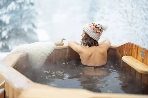 Vrouw ontspannen in warm bad op besneeuwde bergen — Stockfoto