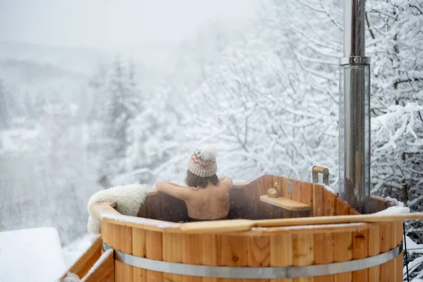 Karlı dağlarda sıcak küvette dinlenen bir kadın. — Stok fotoğraf