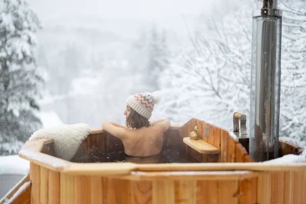 Karlı dağlarda sıcak küvette dinlenen bir kadın. — Stok fotoğraf