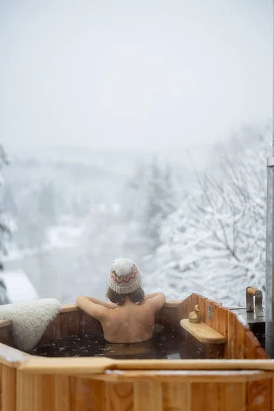 Mulher relaxante em banho quente em montanhas nevadas — Fotografia de Stock