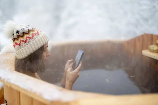 Woman relaxing in hot bath at snowy mountains — Stock Photo, Image