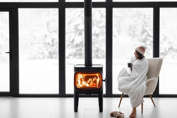 Frau zu Hause mit brennendem Kamin im Winter in der Natur — Stockfoto