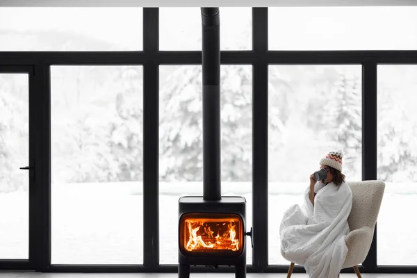 Mujer en casa con chimenea durante el invierno en la naturaleza — Foto de Stock