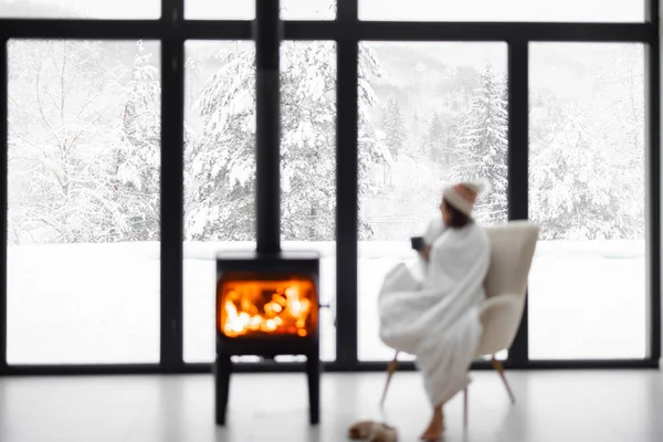Mulher em casa com lareira em chamas durante o inverno na natureza — Fotografia de Stock
