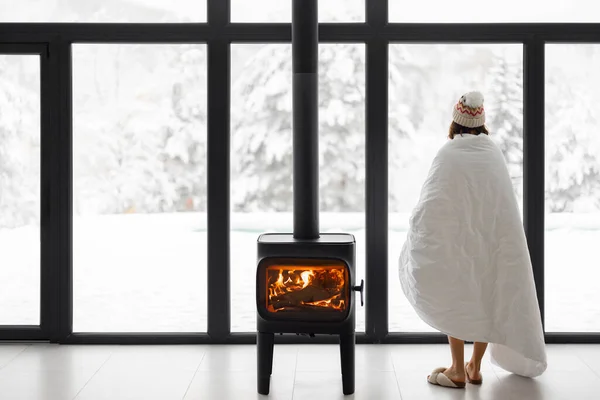 Mujer en casa con chimenea durante el invierno en la naturaleza — Foto de Stock