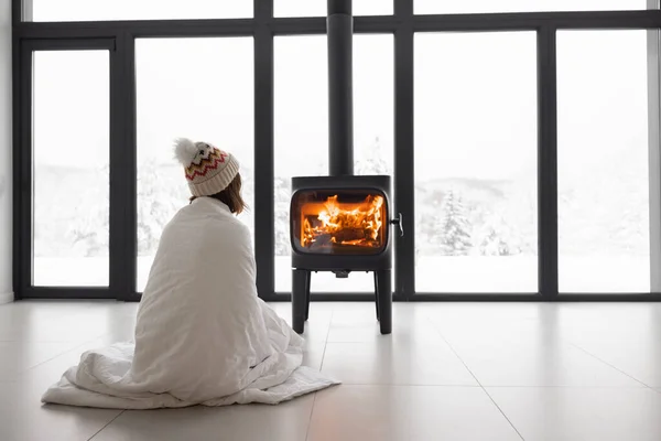 Mujer en casa con chimenea durante el invierno en la naturaleza — Foto de Stock