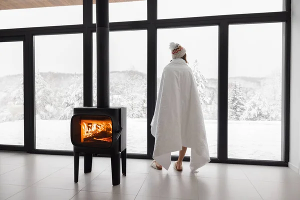 Woman at home with burning fireplace during wintertime on nature — Stock Photo, Image