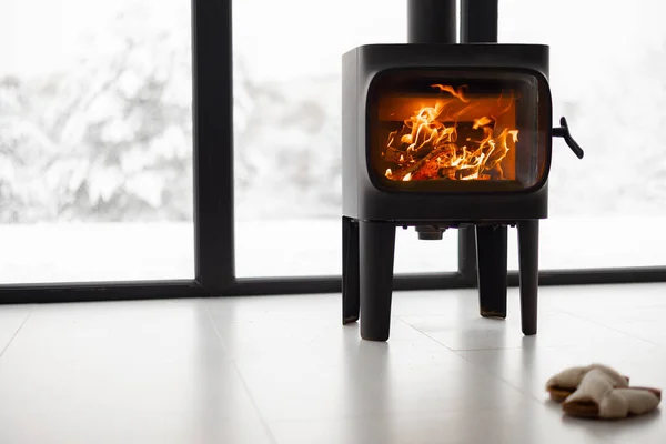 Cozy living space by the burning fireplace at snowy mountains — Stock Photo, Image