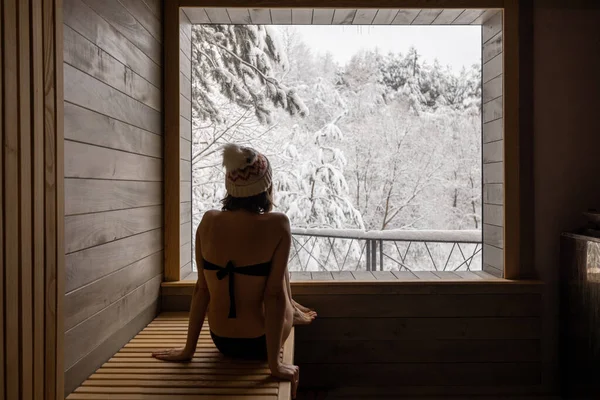 Woman resting in sauna with view on snowy nature — Stock Photo, Image