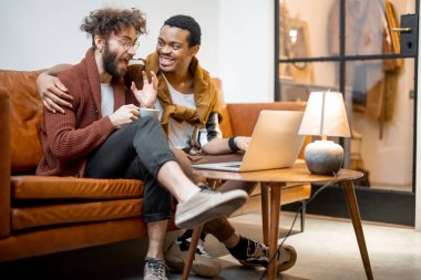 Evdeki kanepede oturan erkek eşcinsel çift.