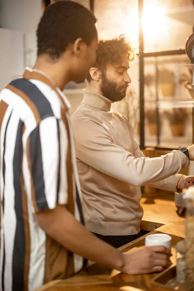 Dos hombres hablando y bebiendo café en la cocina en casa — Foto de Stock