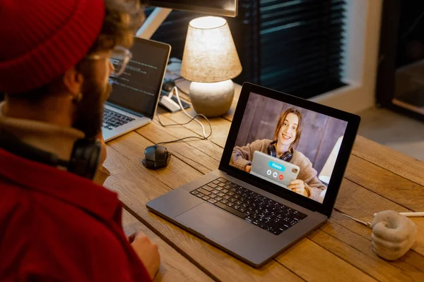 女性の同僚とオンライン会議をしながら自宅で仕事をしている男 — ストック写真