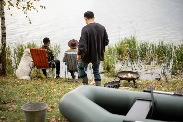 Hombre tomando red de pesca mientras sus amigos de pesca — Foto de Stock