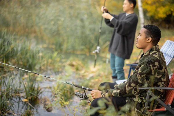 Hombre hablando con amigos varones en la pesca en la naturaleza —  Fotos de Stock