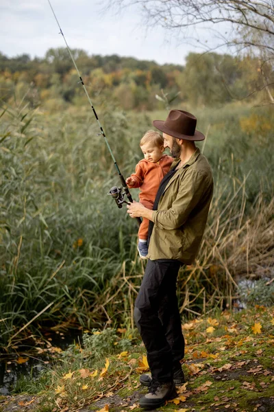 Uomo pesca con il piccolo figlio sulla costa del lago — Foto Stock
