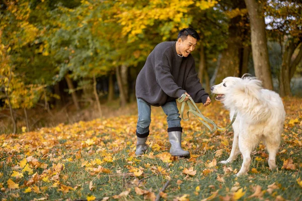 Homme promenade avec chien sur la côte de la rivière à l'automne matin — Photo