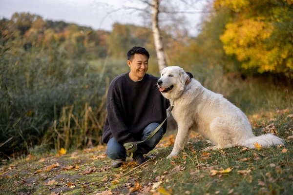 Homme caresse chien et détourner les yeux dans la nature à l'automne — Photo
