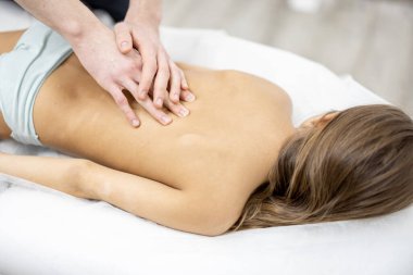 Pediyatrik ortopedist muayenehanedeki 10 yaşındaki kızı muayene ediyor.