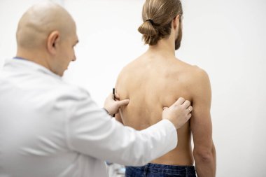 Fizyoterapist tarafından muayene edilen adam.