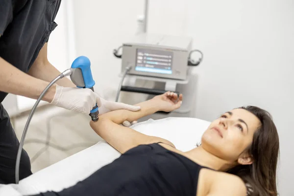 Läkaren tillämpar chock våg terapi på kvinnors knä — Stockfoto