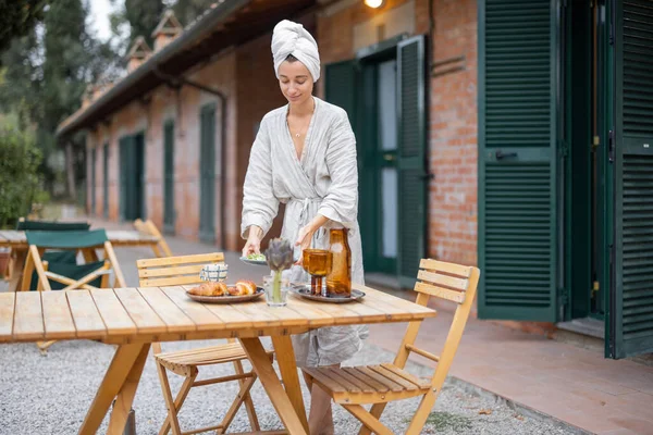 Vrouw dragen voedsel aan tafel voor het ontbijt 's morgens — Stockfoto