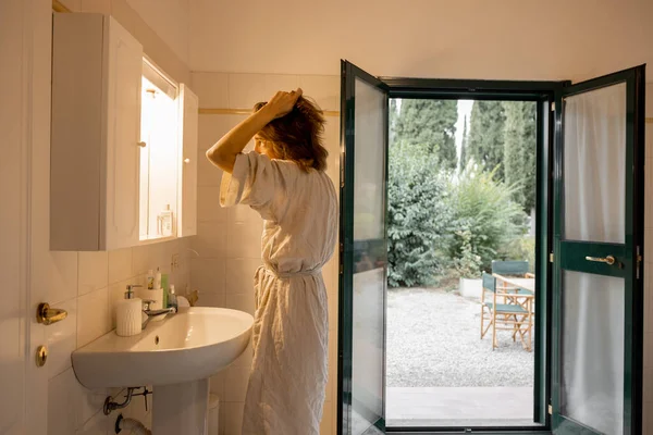 Tyttö kuivaus hiukset kylpyhuoneessa hotellihuoneessa aamulla — kuvapankkivalokuva