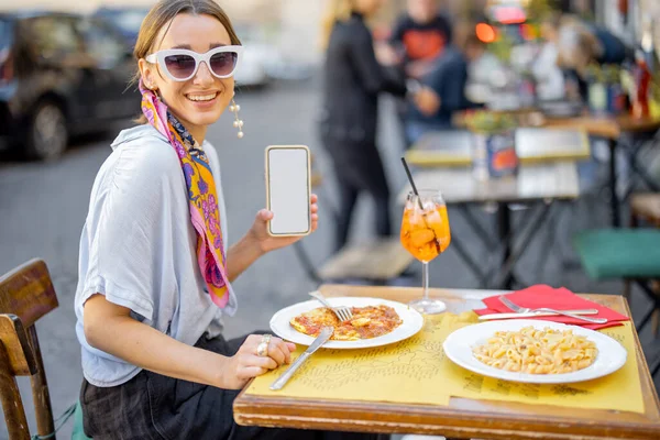 Mujer con teléfono inteligente en el restaurante al aire libre — Foto de Stock