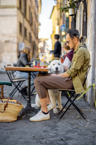 Hombre con su perro en el restaurante italiano al aire libre —  Fotos de Stock