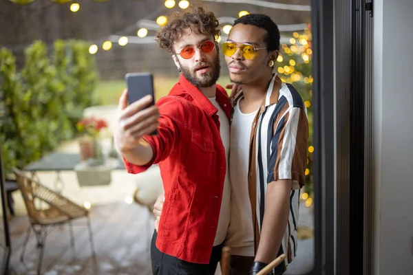Dwóch elegancko ubranych stylowych facetów robiących selfie przez telefon w pomieszczeniach — Zdjęcie stockowe
