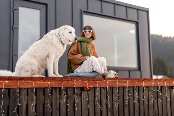 女人带着她的狗躺在大自然的小房子的平台上 — 图库照片