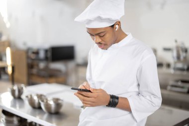 Profesyonel restoranda telefonu olan Latin bir şef.