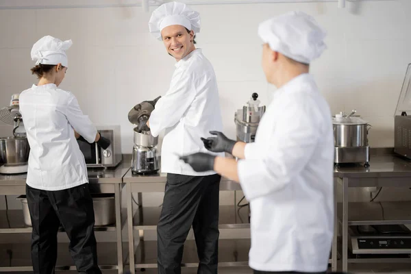 Chefs felizes cozinhar na cozinha profissional — Fotografia de Stock