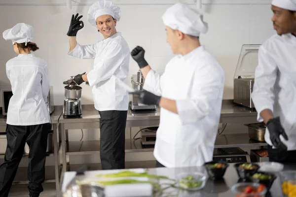 Щасливі кухарі готують на професійній кухні — стокове фото