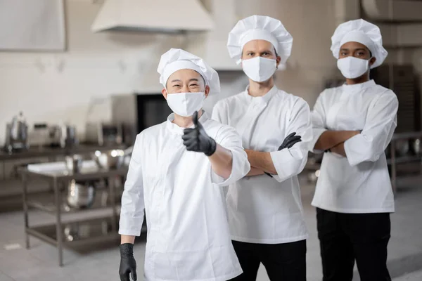 Três chefs bem vestidos juntos na cozinha profissional — Fotografia de Stock