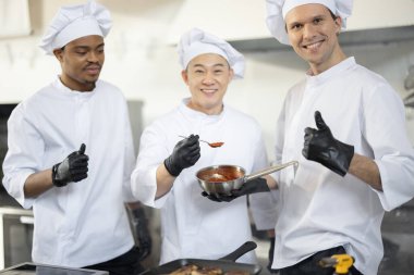 Mutfakta farklı etnik kökenlere sahip üç aşçının portresi.