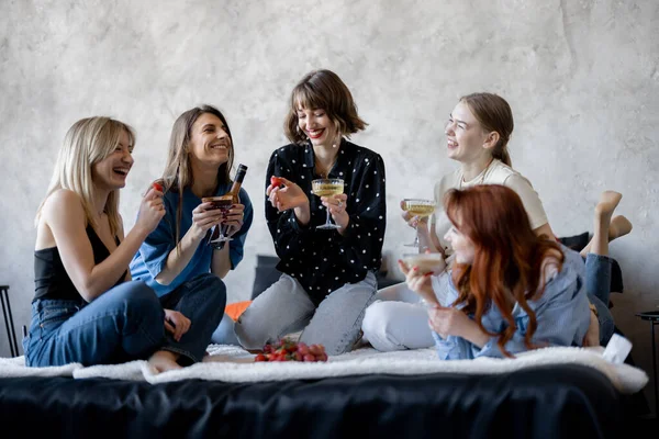 Vuxna flickvänner som har roligt, sitter tillsammans på sängen hemma — Stockfoto