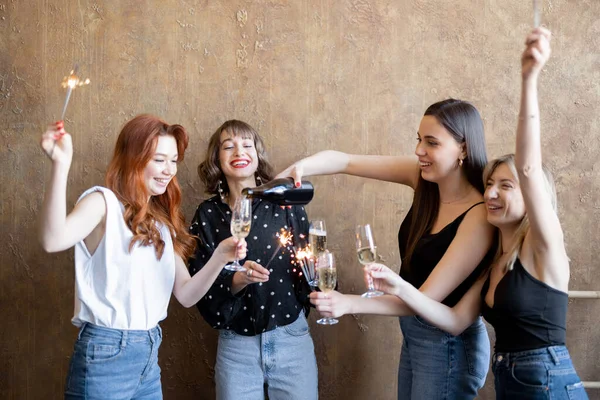 Φιλενάδες πίνουν αφρώδες κρασί και ρίχνουν σπίθες, γιορτάζοντας μαζί σε εσωτερικούς χώρους — Φωτογραφία Αρχείου