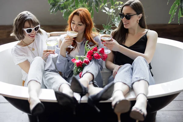 Küvette alkollü içeceklerle oturan üç yetişkin kız arkadaş. — Stok fotoğraf